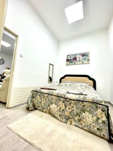 a bedroom with a bed with a floral bedspread at Apartment Tesla in Pančevo