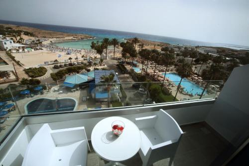 a room with a table and chairs and a view of a resort at Anonymous Beach Hotel (Adults 16+) in Ayia Napa