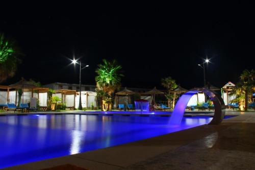 a swimming pool at night with blue lights at Kraal Hotel Vlore in Vlorë