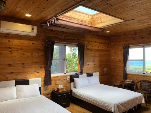 成功的住宿－三仙台星辰民宿，配有木墙和窗户的客房内的两张床