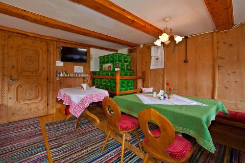 a dining room with a green table and chairs at Landhaus Staudacher in Gerlos