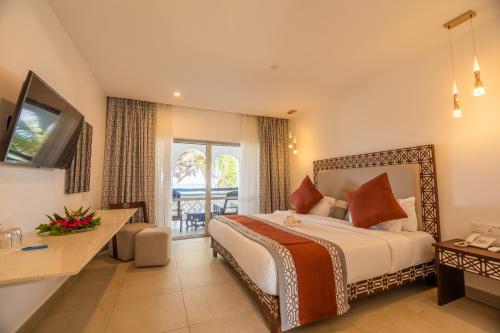 ein Hotelzimmer mit einem Bett und einem Balkon in der Unterkunft Southern Palms Beach Resort in Diani Beach