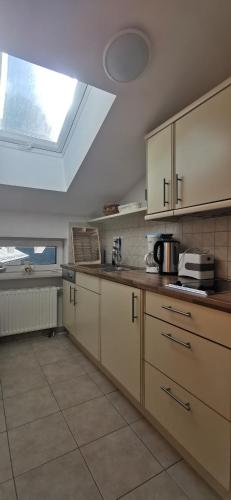a large kitchen with a skylight in the ceiling at Landhaus Thaler in Mittelberg