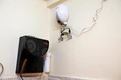 a mirror is hanging on a wall next to a television at Yogvan Luxury 1BHK Apartments Tapovan Rishikesh in Rishīkesh