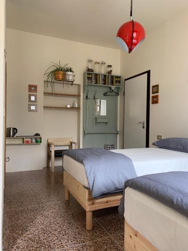 a bedroom with two beds and a red lamp at camiBB in Castel del Rio