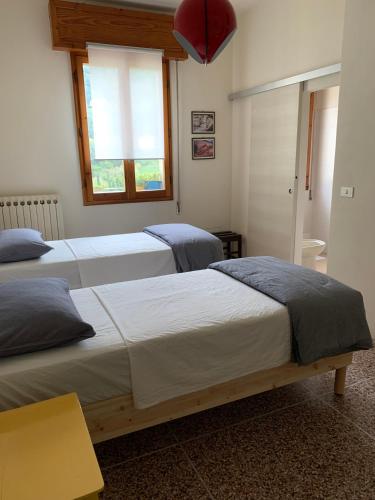 Castel del Rio的住宿－camiBB，一间卧室设有两张床和窗户。