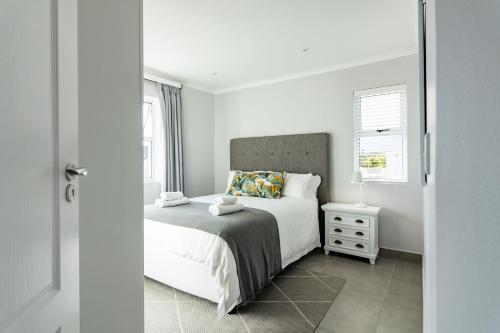 a white bedroom with a bed and a window at Kingswood Hamlet No 5 in George