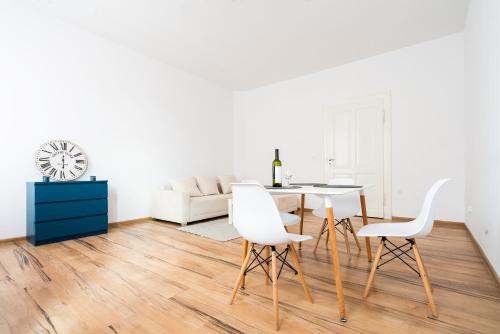 a white living room with a table and chairs at Avalon apart 2 in Legnica