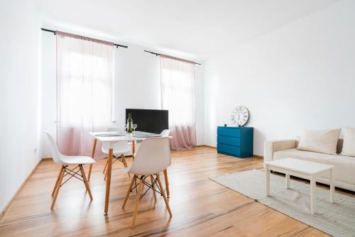ein Wohnzimmer mit einem Tisch, Stühlen und einem Sofa in der Unterkunft Avalon apart 2 in Legnica