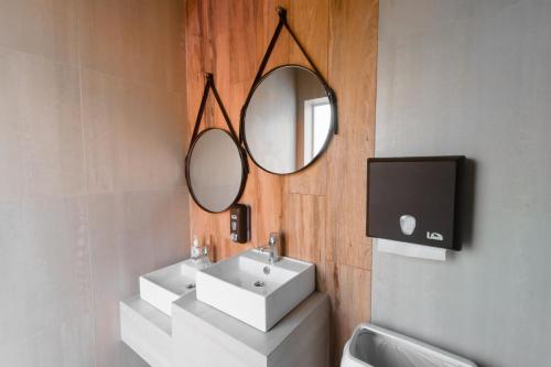 a bathroom with a sink and a mirror and a tv at Aquamarine Family Club in Gagra