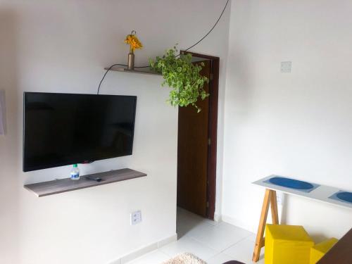 a living room with a flat screen tv on a wall at Recanto dos Mares - Chalés e suíte - Bertioga-SP-Próximo Sesc in Bertioga