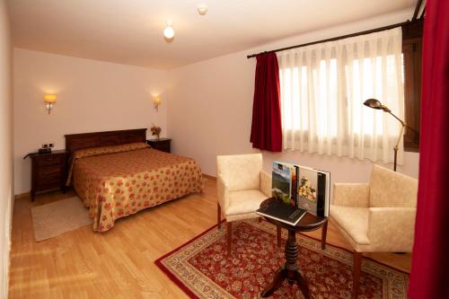 a bedroom with a bed and a chair and a desk at Hotel Rural Casa de Campo in Soto de Cangas