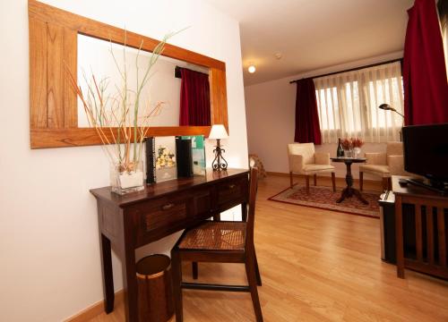 a room with a desk and a living room at Hotel Rural Casa de Campo in Soto de Cangas