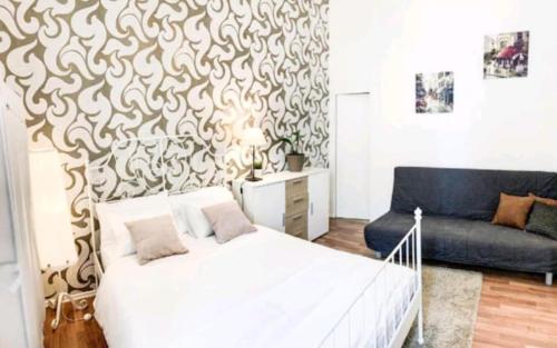 a bedroom with a white bed and a couch at Gallys Apartments in Prague