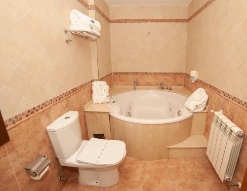 a bathroom with a tub and a toilet and a bath tub at Hotel Rural Casa de Campo in Soto de Cangas