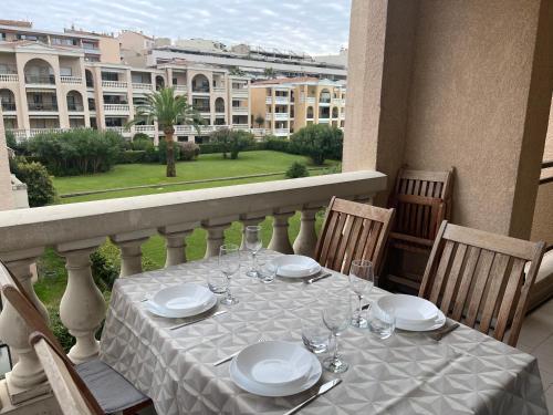 une table avec des assiettes et des verres à vin sur un balcon dans l'établissement Domaine D'Ahmosis, modern 2 bedrooms refurbished apartment, f3 moderne fraichement rénové, au Cannet
