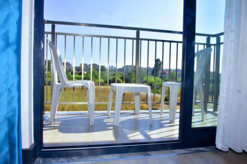 two white chairs sitting on a balcony at KAYA GARDEN OTEL in Side