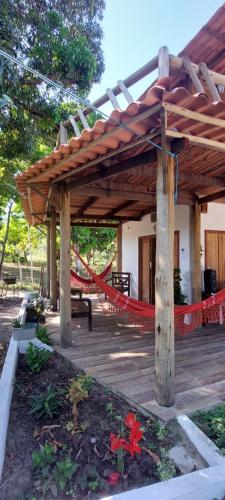 Massarandupio的住宿－Hostel Amicum，木甲板上配有吊床的凉亭