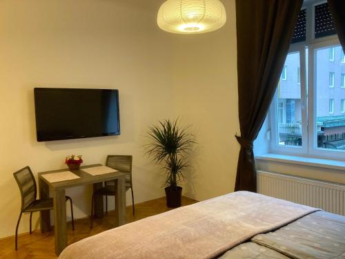 盧比安納的住宿－Twix apartment，卧室配有桌子和墙上的电视。