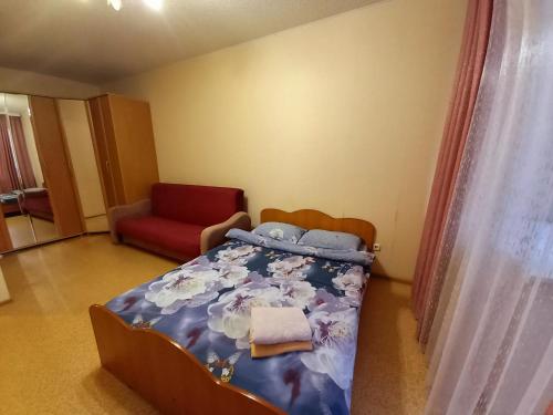スィクティフカルにあるСomfort Apartment Radugaのベッドルーム1室(ベッド1台、赤い椅子付)