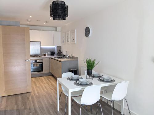 una cucina e una sala da pranzo con tavolo e sedie bianchi di Suffield Lodge by Wycombe Apartments a High Wycombe