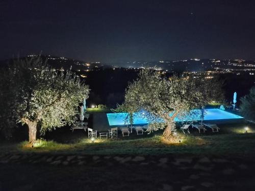 a villa with a swimming pool at night at La Maggiolina Country House in Montelabbate