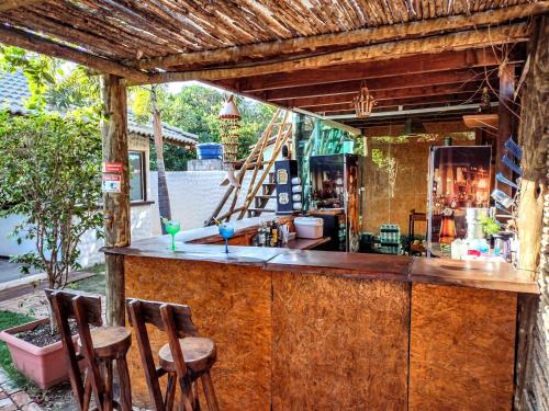 巴拉大的住宿－Pousada Barra del Mundo，木柜台上带三把凳子的酒吧