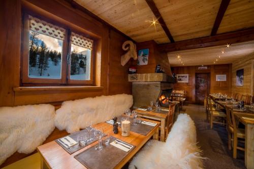 a restaurant with couches and tables and a fireplace at le Chal'heureux in Vars