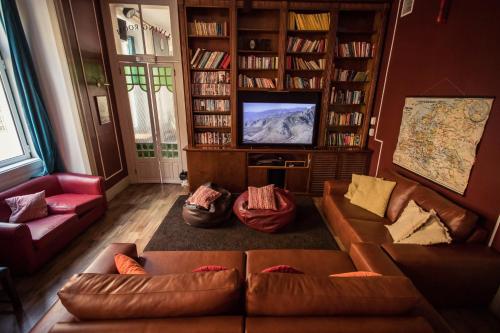 リスボンにあるホーム リスボン ホステルのソファとテレビのあるリビングルーム