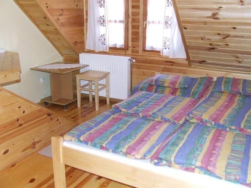 a bedroom with a bed and a table in it at Ezerjó Ökofogadó in Őriszentpéter