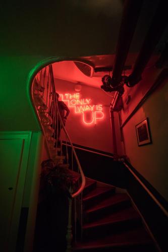 a stairway with a neon sign that says happy birthday at Home Lisbon Hostel in Lisbon