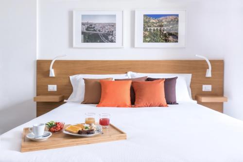 a bed with a tray of food on it at Aurà - Guest House Iblea in Ragusa