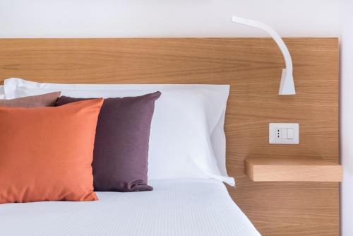 a bedroom with a bed with pillows and a lamp at Aurà - Guest House Iblea in Ragusa