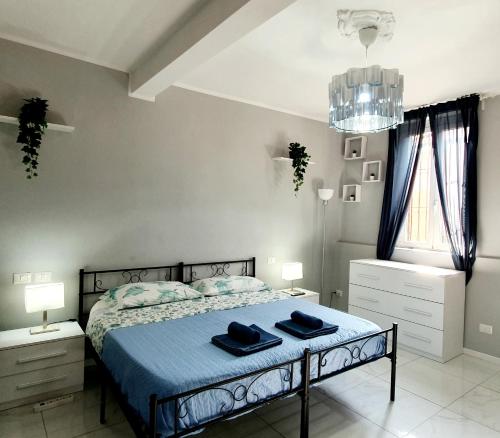 a bedroom with a bed with blue sheets and a chandelier at LA MAISON DELUXE LODI in Lodi