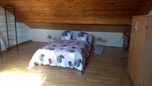 um quarto com uma cama e um tecto de madeira em LA PETITE MAISON em Saint-Loup-Géanges
