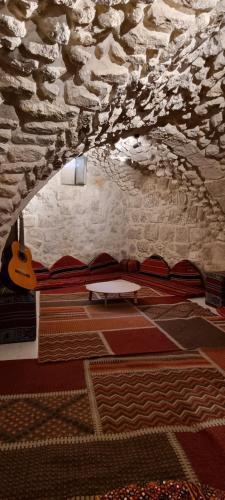 a room with a table and a stone wall at New Citadel Hostel in Jerusalem