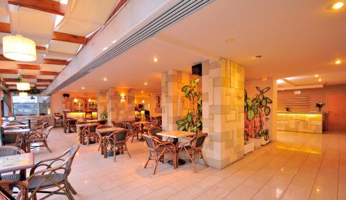 a restaurant with tables and chairs in a room at Carina Hotel in Rhodes Town