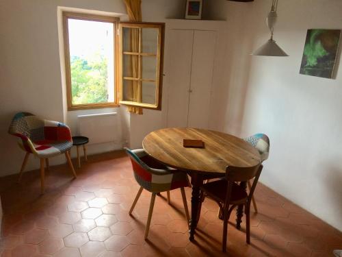 a dining room with a wooden table and chairs at LA MAISON D’ALICE in Sault-de-Vaucluse