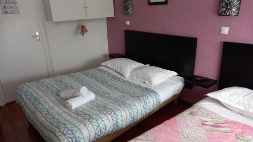 a bedroom with a bed with two white towels on it at Hotellerie Normande in Dozulé