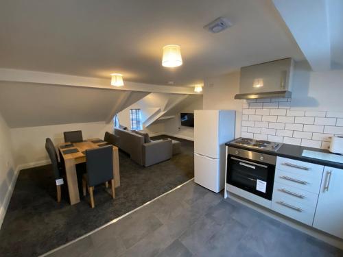 a kitchen and living room with a table and a couch at Kings Court Modern Aparthotel, Town Centre - Blackpool Resort Collection in Blackpool