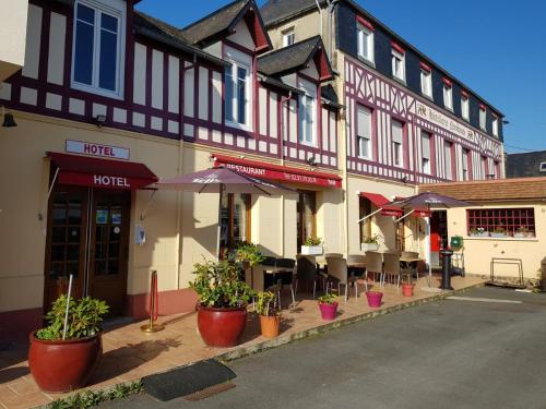 a row of buildings with potted plants on a street at Hotellerie Normande in Dozulé