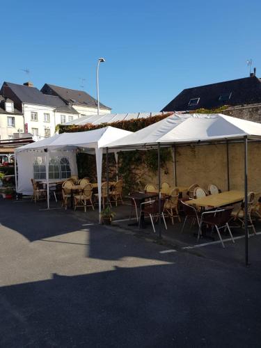 a group of tables and chairs under a white tent at Hotellerie Normande in Dozulé