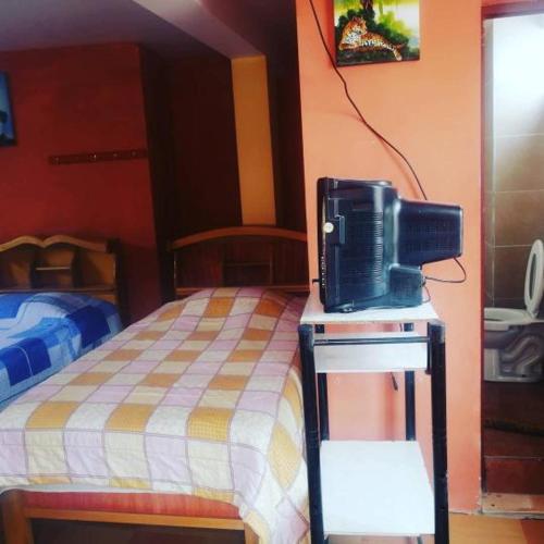 a bedroom with a bed and a tv on a table at Hostal Puerto Alegre in Copacabana