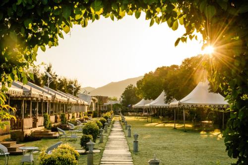 a row of buildings with white umbrellas in a park at Rawai Luxury Tents Pushkar in Pushkar
