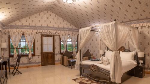 a bedroom with a canopy bed in a room at Rawai Luxury Tents Pushkar in Pushkar