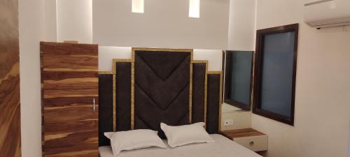 a bedroom with a bed with two white pillows at Hotel Golden Crown in Amritsar