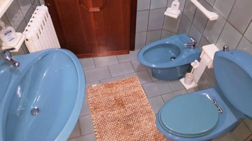 y baño con bañera azul, aseo y bidet. en La casa del mugnaio 2019, en Castronuovo di Sicilia