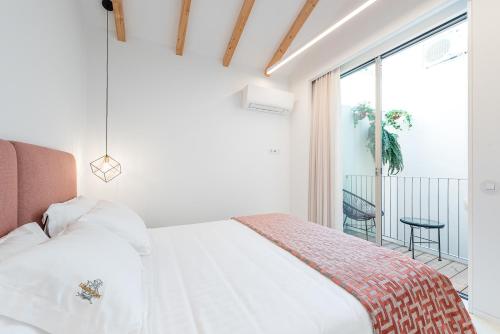 a white bedroom with a bed and a balcony at Lidador 116 Apartments in Vila do Conde