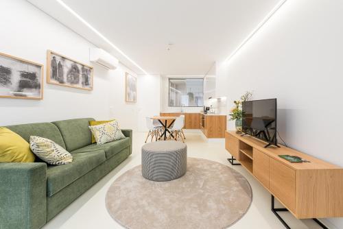 a living room with a green couch and a tv at Lidador 116 Apartments in Vila do Conde