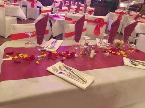 a table with a white table cloth with glasses and napkins at Hotellerie Normande in Dozulé